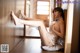 A naked woman sitting on the floor in a room.