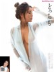 A woman in a white robe is posing for a magazine.