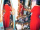 A woman in a red dress standing in front of a mirror.