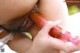 A woman is holding a pink dildo in her mouth.