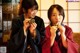 A couple of women sitting next to each other eating food.