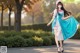 A woman in a blue and white dress is walking down the street.